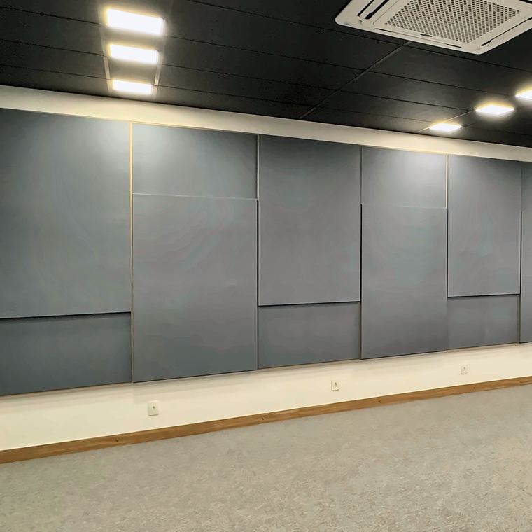 Parede de auditório revestida com painéis acústicos em tecido